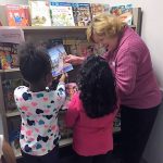 Two students pick out new books with the encouragement of an Assistance League of Birmingham member.