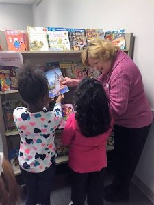 Two students pick out new books with the encouragement of an Assistance League of Birmingham member.
