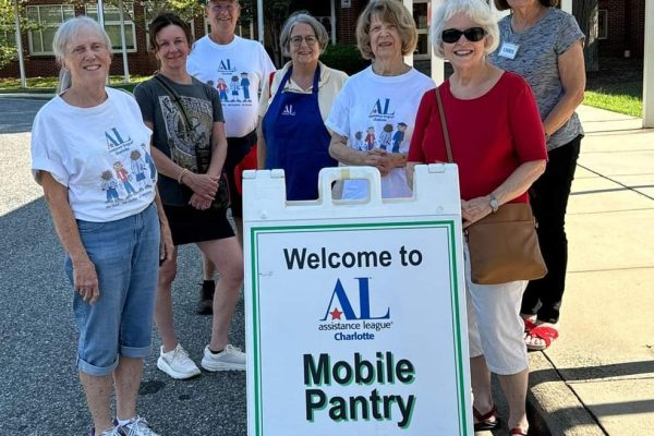 Volunteers behind Mobile Food Pantry sign