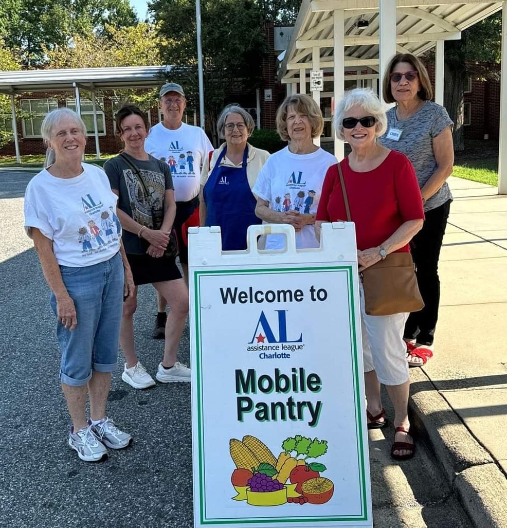 Volunteers behind Mobile Food Pantry sign